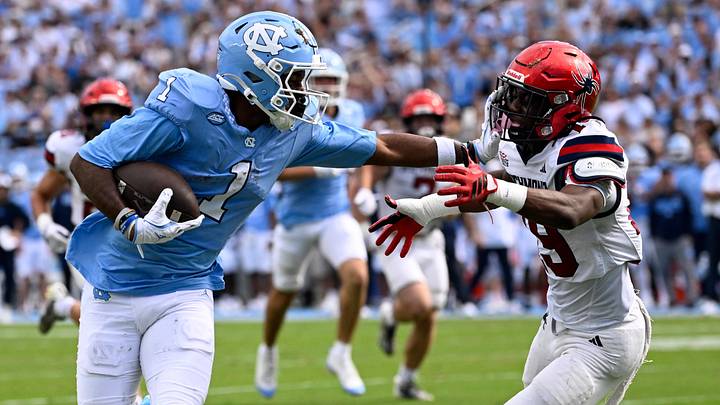 Sep 13, 2025; Chapel Hill, North Carolina, USA; North Carolina Tar Heels wide receiver Jordan Shipp (1) scores a touchdown as Richmond Spiders defensive back Lee Bruner IV (19) defends in the first quarter at Kenan Stadium. Mandatory Credit: Bob Donnan-Imagn Images