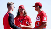 Cincinnati Reds pitcher Rhett Lowder (25), center, has a conversation with a staff member, left, and non-roster invitee Chase Burns (81) after a pitching session during spring training, , Feb. 21, 2025, at the Cincinnati Reds Player Development Complex in Goodyear, Ariz.