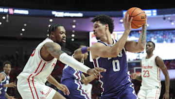 Jan 6, 2025; Houston, Texas, USA; TCU Horned Frogs guard Brendan Wenzel (0) controls the ball as Houston Cougars forward J'Wan Roberts (13) defends during the second half at Fertitta Center. Mandatory Credit: Troy Taormina-Imagn Images