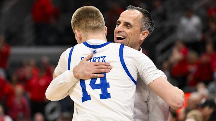 Mar 9, 2025; St. Louis, Missouri, USA;  Drake Bulldogs head coach Ben McCollum hugs guard Bennett Stirtz (14) after defeating the Bradley Braves to win the Missouri Valley Conference Tournament Championship at Enterprise Center. Mandatory Credit: Jeff Curry-Imagn Images
