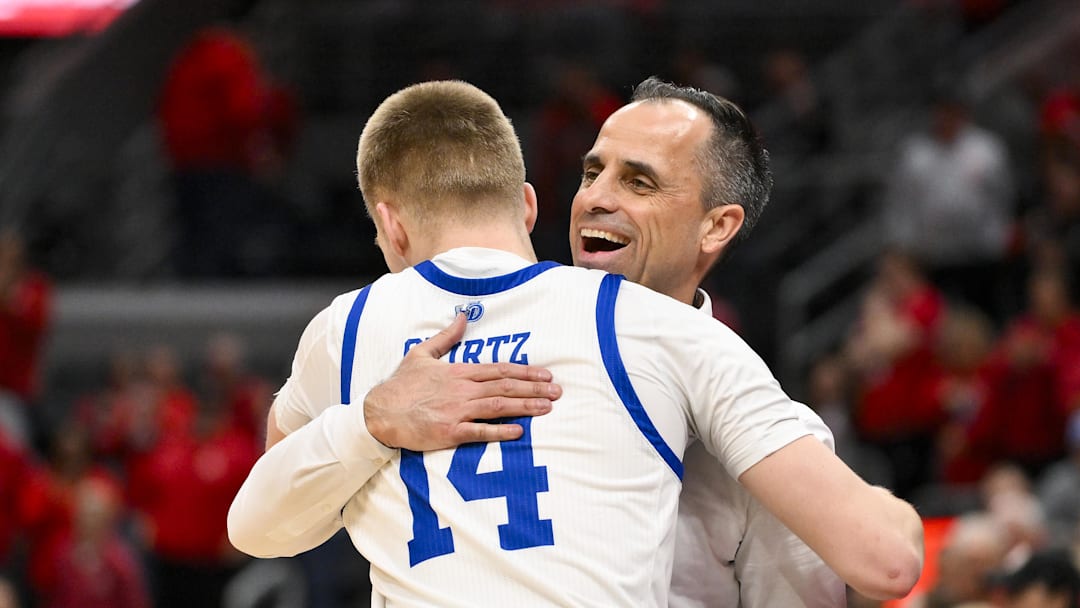 Mar 9, 2025; St. Louis, Missouri, USA;  Drake Bulldogs head coach Ben McCollum hugs guard Bennett Stirtz (14) after defeating the Bradley Braves to win the Missouri Valley Conference Tournament Championship at Enterprise Center. Mandatory Credit: Jeff Curry-Imagn Images