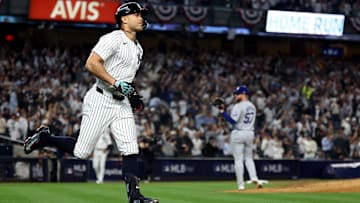 Oct 30, 2024; New York, New York, USA; New York Yankees designated hitter Giancarlo Stanton (27) reacts after hitting a home run against Los Angeles Dodgers pitcher Ryan Brasier (57) during the third inning in game five of the 2024 MLB World Series at Yankee Stadium.