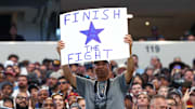 A fan holds up a sign during a game between the Dallas Cowboys and the Washington Commanders at AT&T Stadium. 
