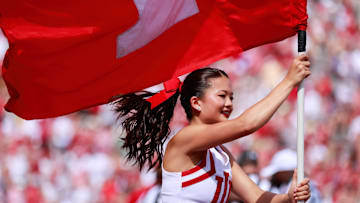 An Indiana University cheerleader carries a flag after the...