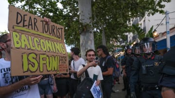 A protester is seen showing a placard in front of a line of...