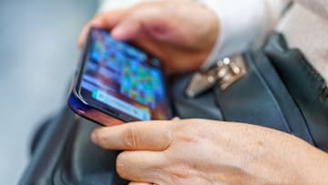 Hands of a woman playing a game on her smartphone...
