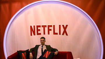 A man poses for a photo near a Netflix logo at their stall...