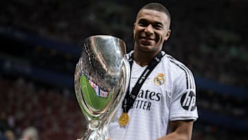 Kylian Mbappe of Real Madrid CF poses with the trophy during...