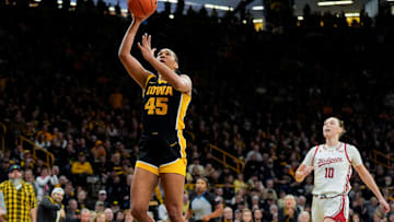Iowa forward Hannah Stuelke (45) shoots a transition layup as Wisconsin guard Halle Douglass (10) trails during a Big Ten conference game Sunday, March 2, 2025 at Carver-Hawkeye Arena in Iowa City, Iowa.