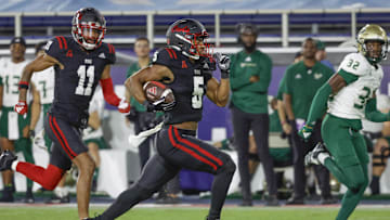 Nov 1, 2024; Boca Raton, Florida, USA;  Florida Atlantic Owls running back CJ Campbell Jr. (5) runs the ball getting past South Florida Bulls defensive back James Chenault (32) as Owls wide receiver Marlyn Johnson (11) follows along during the second half at FAU Stadium. Mandatory Credit: Reinhold Matay-Imagn Images
