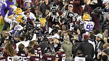 Nov 26, 2022; College Station, Texas, USA;  Texas A&M Aggies head coach Jimbo Fisher and LSU Tigers head coach Brian Kelly meet amongst the crowd after the game at Kyle Field. Mandatory Credit: Maria Lysaker-Imagn Images
