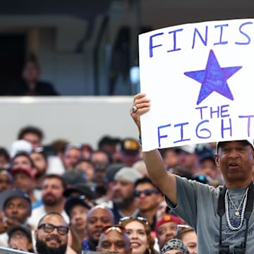 A fan holds up a sign during a game between the Dallas Cowboys and the Washington Commanders at AT&T Stadium. 
