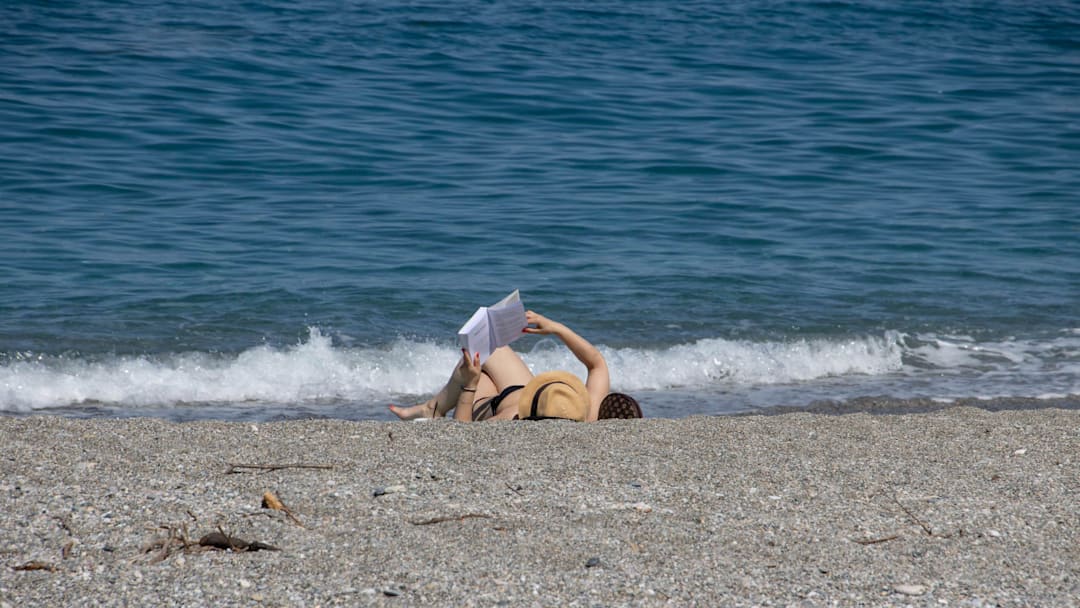 Woman reading on the beach in Greece