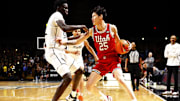 Feb 23, 2025; Orlando, Florida, USA;  Utah Utes forward Mike Sharavjamts (25) dribbles against Central Florida Knights center Moustapha Thiam (52) at Addition Financial Arena. Mandatory Credit: Russell Lansford-Imagn Images