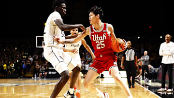 Feb 23, 2025; Orlando, Florida, USA;  Utah Utes forward Mike Sharavjamts (25) dribbles against Central Florida Knights center Moustapha Thiam (52) at Addition Financial Arena. Mandatory Credit: Russell Lansford-Imagn Images