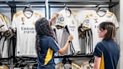Workers organize and prepare Real Madrid football team shirt...