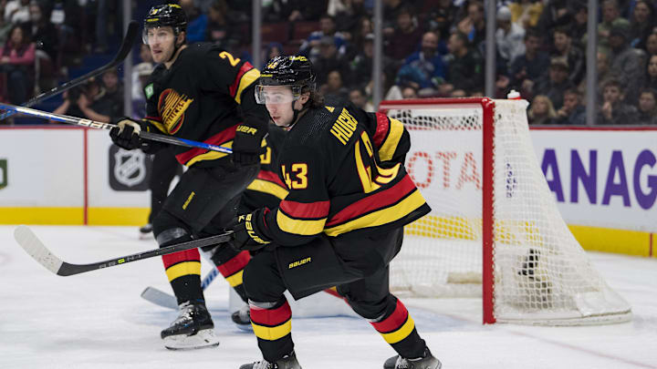 Jan 18, 2023; Vancouver, British Columbia, CAN; Vancouver Canucks defenseman Luke Schenn (2) and defenseman Quinn Hughes (43) skate against the Tampa Bay Lightning in the second period at Rogers Arena. Mandatory Credit: Bob Frid-Imagn Images