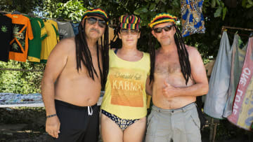 Tourist friends model dreadlocks Jamaican hats on the beach...