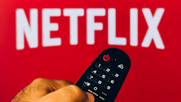 In this photo illustration, a hand holding a TV remote...