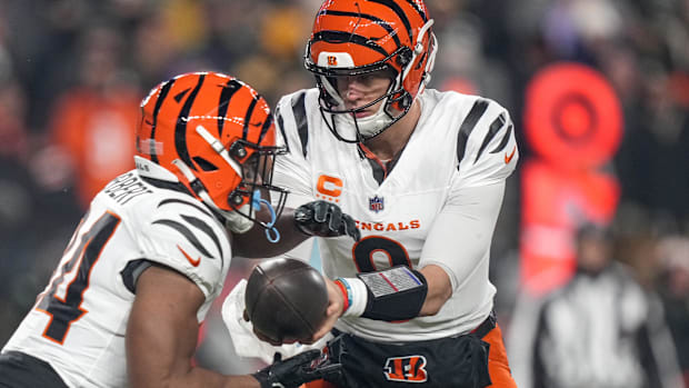 Cincinnati Bengals quarterback Joe Burrow (9) hands off to running back Khalil Herbert (34) against the Pittsburgh Steelers