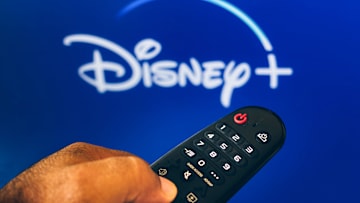 In this photo illustration, a hand holding a TV remote...