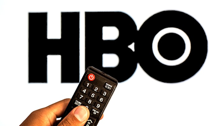 In this photo illustration a close-up of a hand holding a TV...
