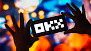 In this photo illustration, the OKX logo is displayed on a...