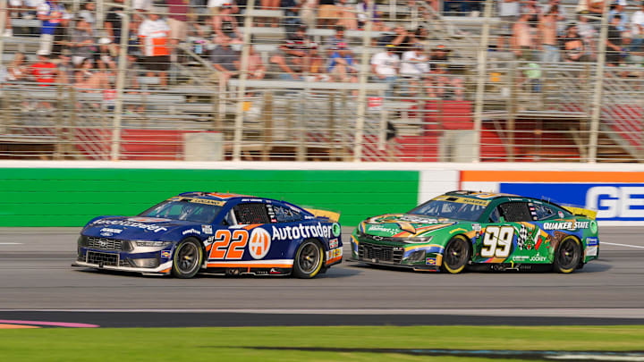 Sep 8, 2024; Hampton, Georgia, USA; NASCAR Cup Series driver Joey Logano (22) and NASCAR Cup Series driver Daniel Suarez (99) come around for the final laps at Atlanta Motor Speedway. Mandatory Credit: Jason Allen-Imagn Images