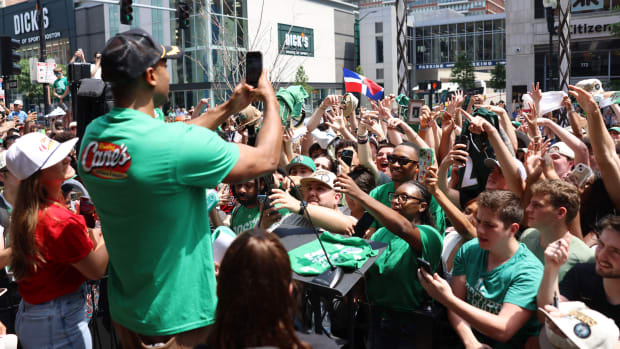 Al Horford uses his phone to document the sea of people lined up outside of Raising Cane's on Boylston Street to meet him.