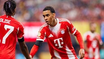 Jamal Musiala klatscht mit Teamkollege Olise ab