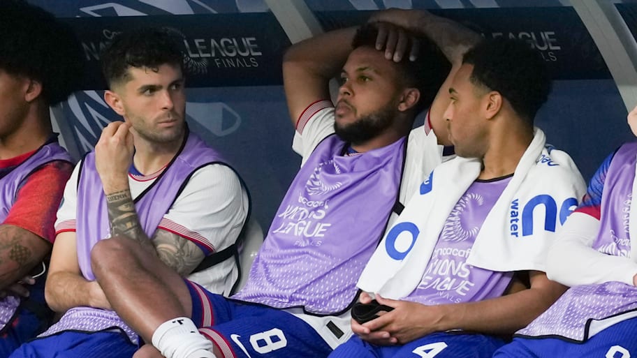 Weston McKennie displaying negative body language on the bench next to Christian Pulisic and Tyler Adams.