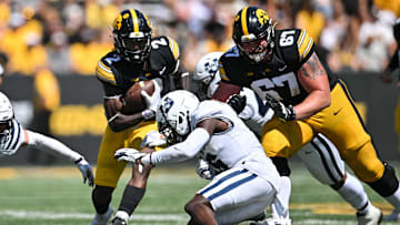Sep 2, 2023; Iowa City, Iowa, USA; Iowa Hawkeyes running back Kaleb Johnson (2) and offensive lineman Gennings Dunker (67) in action as Utah State Aggies safety Ike Larsen (6) makes the tackle during the second quarter at Kinnick Stadium. Mandatory Credit: Jeffrey Becker-Imagn Images
