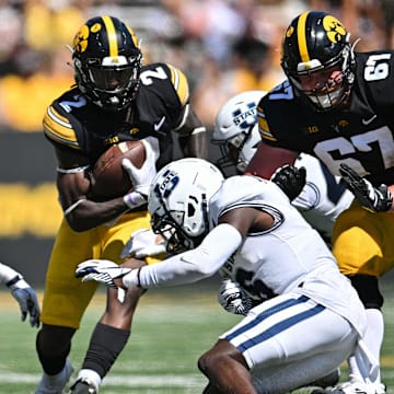 Sep 2, 2023; Iowa City, Iowa, USA; Iowa Hawkeyes running back Kaleb Johnson (2) and offensive lineman Gennings Dunker (67) in action as Utah State Aggies safety Ike Larsen (6) makes the tackle during the second quarter at Kinnick Stadium. Mandatory Credit: Jeffrey Becker-Imagn Images