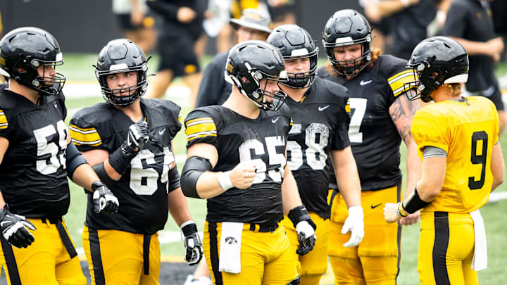 Aug 9, 2025; Iowa offensive linemen Trevor Lauck (59) Leighton Jones (64) Logan Jones (65) Kade Pieper (58) and Gennings Dunker (67) huddle up with quarterback Hank Brown (9) during the Hawkeyes Kids Day NCAA football open practice at Kinnick Stadium in Iowa City, Iowa. Mandatory Credit: Joseph Cress for the Des Moines Register