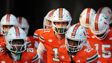 Nov 15, 2025; Miami Gardens, Florida, USA; Miami Hurricanes quarterback Carson Beck (center) enters the field to warm up before the game against NC State Wolfpack at Hard Rock Stadium. Mandatory Credit: Sam Navarro-Imagn Images