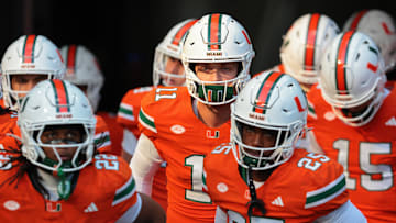 Nov 15, 2025; Miami Gardens, Florida, USA; Miami Hurricanes quarterback Carson Beck (center) enters the field to warm up before the game against NC State Wolfpack at Hard Rock Stadium. Mandatory Credit: Sam Navarro-Imagn Images