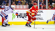 Nov 3, 2024; Calgary, Alberta, CAN; Calgary Flames left wing Andrei Kuzmenko (96) controls the puck against Edmonton Oilers right wing Vasily Podkolzin (92) during the third period at Scotiabank Saddledome. Mandatory Credit: Sergei Belski-Imagn Images