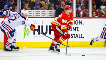 Nov 3, 2024; Calgary, Alberta, CAN; Calgary Flames left wing Andrei Kuzmenko (96) controls the puck against Edmonton Oilers right wing Vasily Podkolzin (92) during the third period at Scotiabank Saddledome. Mandatory Credit: Sergei Belski-Imagn Images