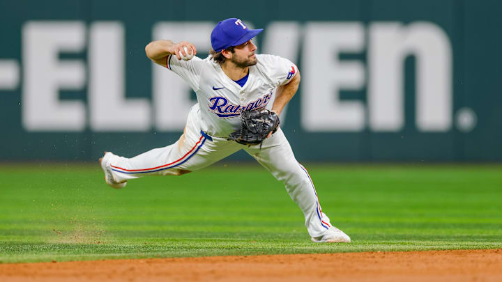 Sep 4, 2024; Arlington, Texas, USA; Texas Rangers shortstop Josh Smith (8) attempts to make a throw over to first base during the third inning against the New York Yankees at Globe Life Field. Mandatory Credit: Andrew Dieb-Imagn Images