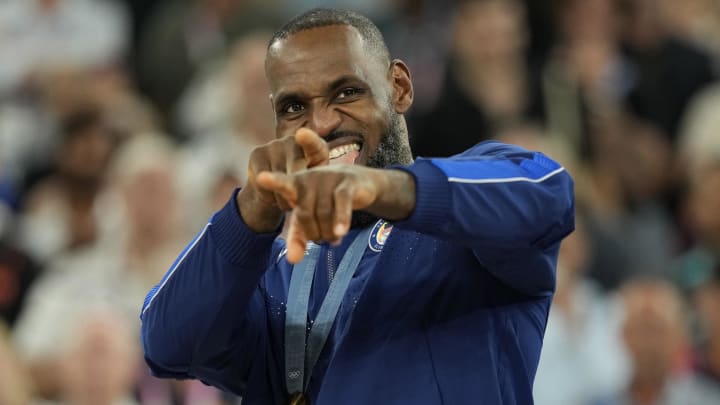 United States guard LeBron James celebrates with the Olympic gold medal after their  game against France.