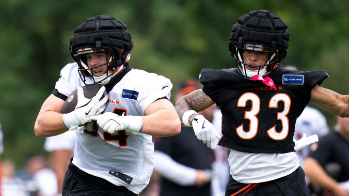 Cincinnati Bengals tight end Tanner McLachlan (84) makes a catch as Cincinnati Bengals safety Daijahn Anthony (33) makes a stop at Cincinnati Bengals training camp on the Kettering Health Practice Fields in Cincinnati on Sunday, July 28, 2024.