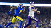 Jan 13, 2025; Glendale, AZ, USA; Minnesota Vikings quarterback Sam Darnold (14) is pursued by Los Angeles Rams linebacker Jared Verse (8) during an NFC wild card game at State Farm Stadium. Mandatory Credit: Mark J. Rebilas-Imagn Images