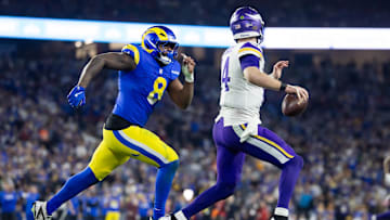 Jan 13, 2025; Glendale, AZ, USA; Minnesota Vikings quarterback Sam Darnold (14) is pursued by Los Angeles Rams linebacker Jared Verse (8) during an NFC wild card game at State Farm Stadium. Mandatory Credit: Mark J. Rebilas-Imagn Images