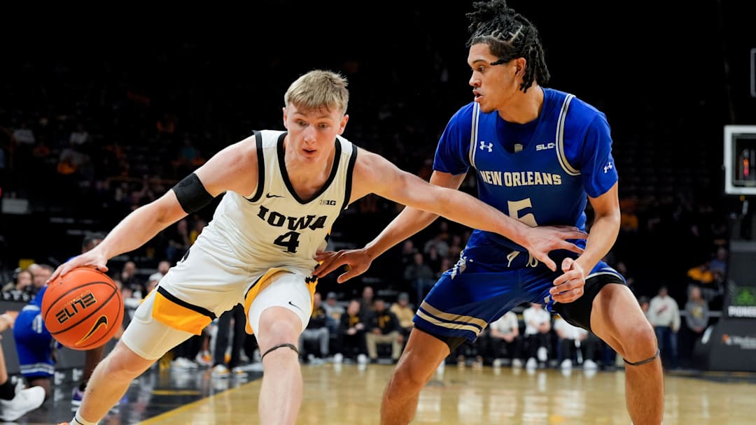 Iowa Hawkeyes guard Josh Dix (4) drives toward the baseline as New Orleans Privateers guard James White (5) defends Sunday, Dec. 15, 2024 at Carver-Hawkeye Arena in Iowa City, Iowa.