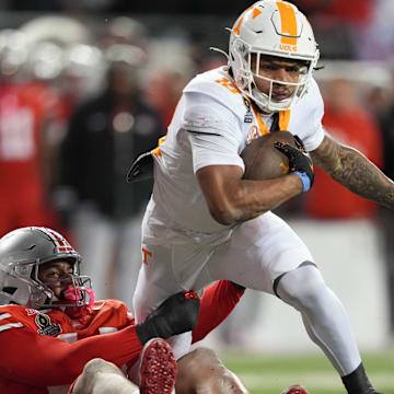 Tennessee running back DeSean Bishop (18) is grabbed by Ohio State defensive edge JT Tuimoloau (44) during an NCAA college football playoff game on Saturday, Dec. 21, 2024, in Columbus, Ohio.