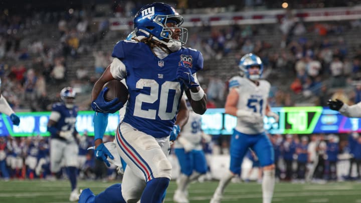 Aug 8, 2024; East Rutherford, New Jersey, USA; New York Giants running back Eric Gray (20) scores a rushing touchdown in front of Detroit Lions cornerback Amik Robertson (21) and cornerback Morice Norris (39) during the first half at MetLife Stadium.  