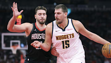 Nov 21, 2025; Houston, Texas, USA; Denver Nuggets center Nikola Jokic (15) controls the ball as Houston Rockets center Alperen Sengun (28) defends during the fourth quarter at Toyota Center.