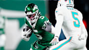 New York Jets wide receiver Garrett Wilson (5) runs with the ball as he tries to find a way past Miami Dolphins cornerback Jalen Ramsey (5), Sunday January 5, 2025, in East Rutherford.