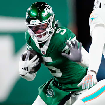 New York Jets wide receiver Garrett Wilson (5) runs with the ball as he tries to find a way past Miami Dolphins cornerback Jalen Ramsey (5), Sunday January 5, 2025, in East Rutherford.