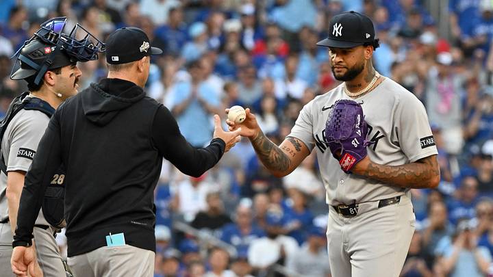 Oct 4, 2025; Toronto, Ontario, CAN; New York Yankees pitcher Luis Gil (81) is relieved by manager Aaron Boone (17) in the third inning against the Toronto Blue Jays during game one of the ALDS round for the 2025 MLB playoffs at Rogers Centre. Mandatory Credit: Dan Hamilton-Imagn Images
